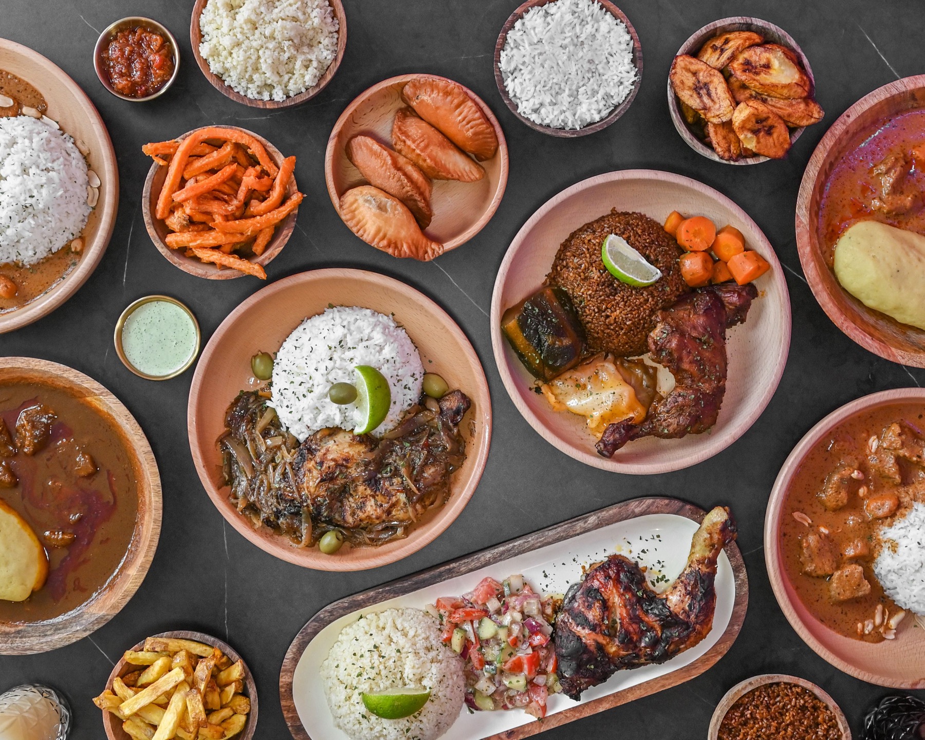 Assortiment de plats West Afri'K : thiéboudienne, yassa, mafé, riz, alloco, pastels et jus maison